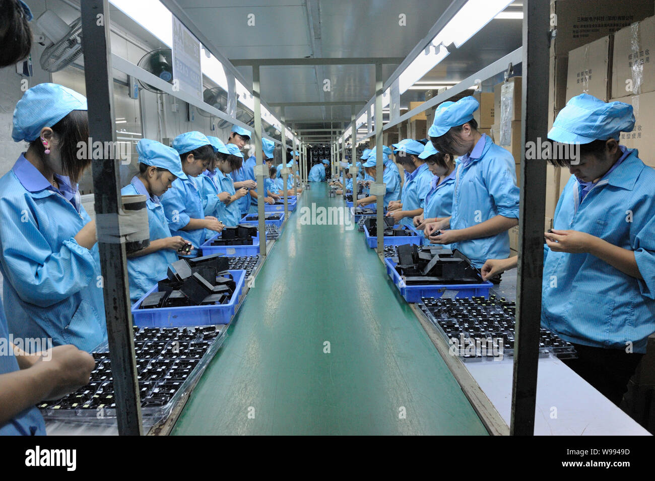 FILE--lavoratori cinesi fanno parti di telefoni cellulari in fabbrica di  Shenzhen Sanhexin Electronic Technology Co., Ltd. nella città di Shenzhen,  sud Chinas Foto stock - Alamy