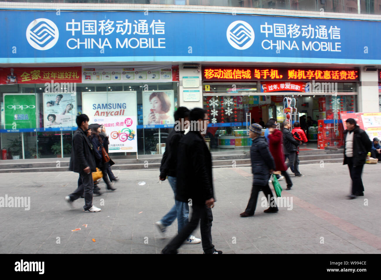 I residenti locali a piedi passato un ramo di China Mobile a Chongqing Cina, 23 febbraio 2011. China Mobile Ltd., i mondi più grande operatore wireless b Foto Stock