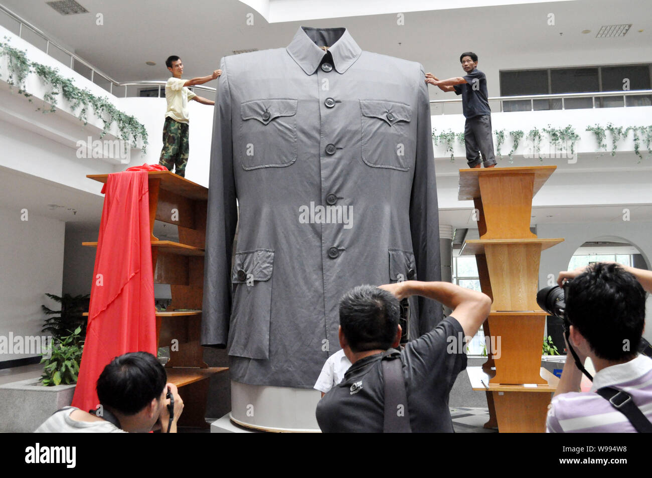 Lavoratori regolare un enorme tunica cinese suit, noto anche come il Sun Yat-sen Suit, durante una cerimonia di inaugurazione a Zhejiang tessile e della moda College in Ni Foto Stock