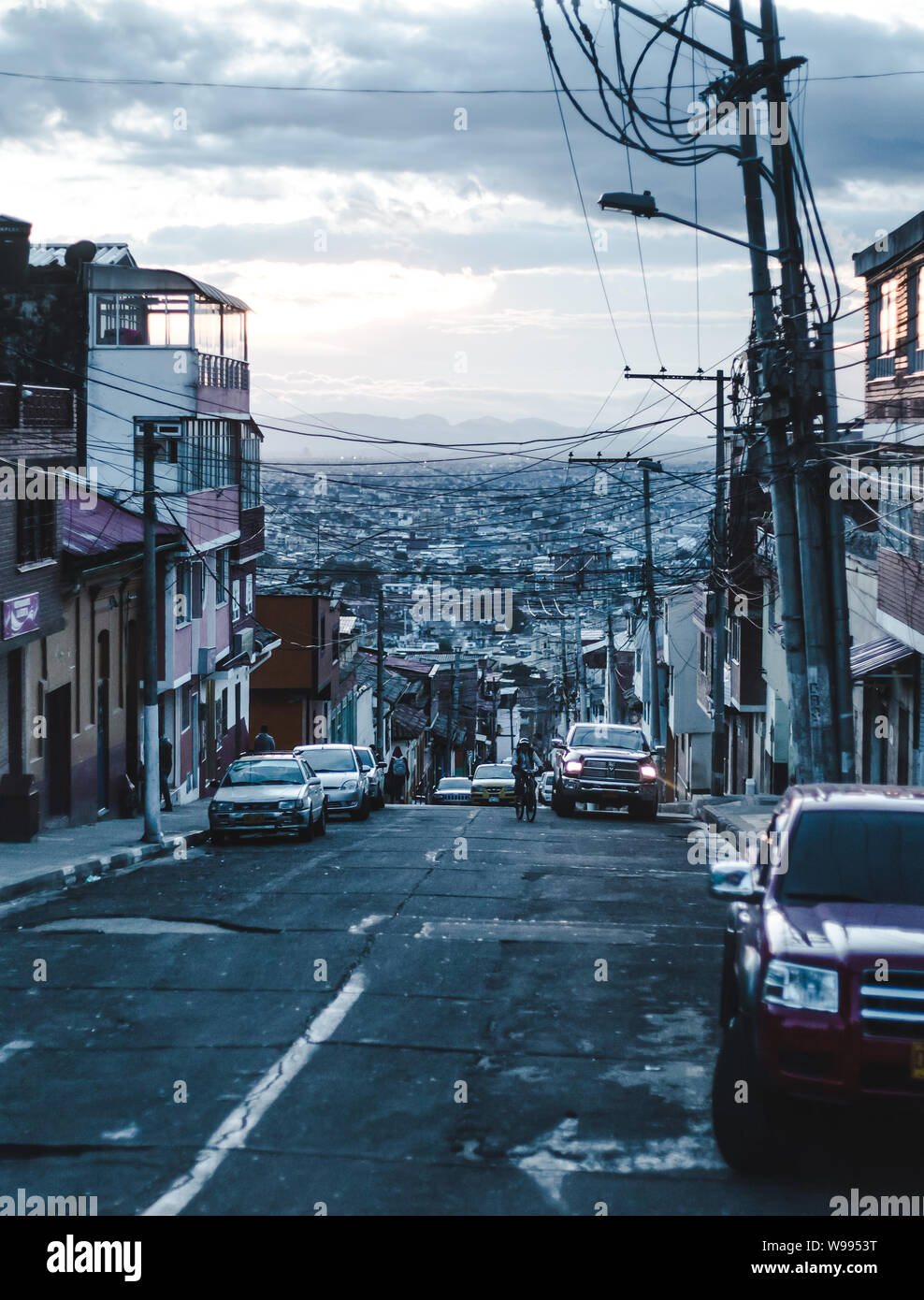 Strada di un meno sviluppato barrio della metropoli tentacolare di Bogotà, Colombia la città capitale al tramonto come notte entra in Foto Stock
