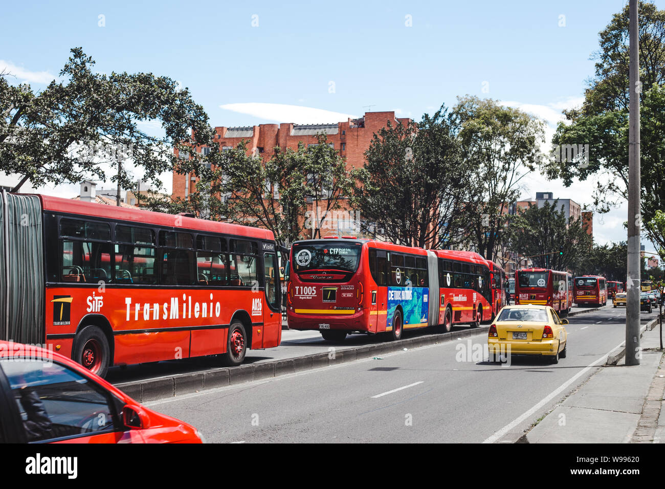 La Transmilenio rosso sistema di autobus pubblici nella corsia degli autobus attraverso il centro di Bogotá, Colombia la città capitale della Foto Stock