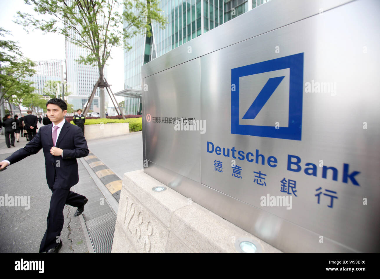 --FILE -- un giovane uomo cinese passeggiate passato il logo della Deusche Bank a Shanghai in Cina, 18 aprile 2011. Hung Huang, una celebrità rivista editore e la Foto Stock