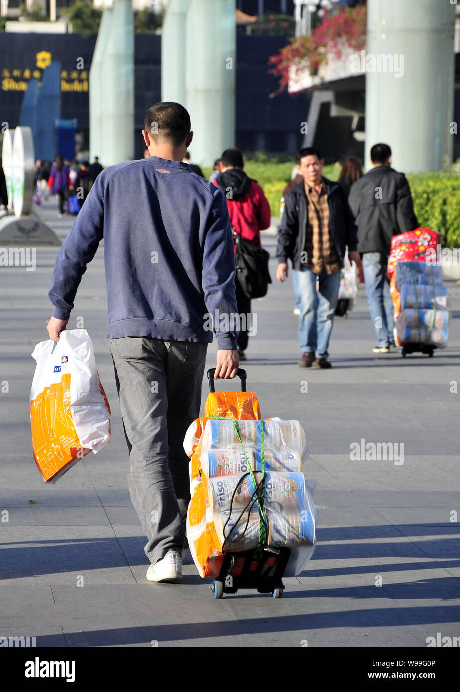 --FILE--acquirenti cinesi tirare loro carrelli caricati con il bambino il latte in polvere hanno comprato a Hong Kong dopo il passaggio della Porta di Luohu nella città di Shenzhen, sud Chi Foto Stock