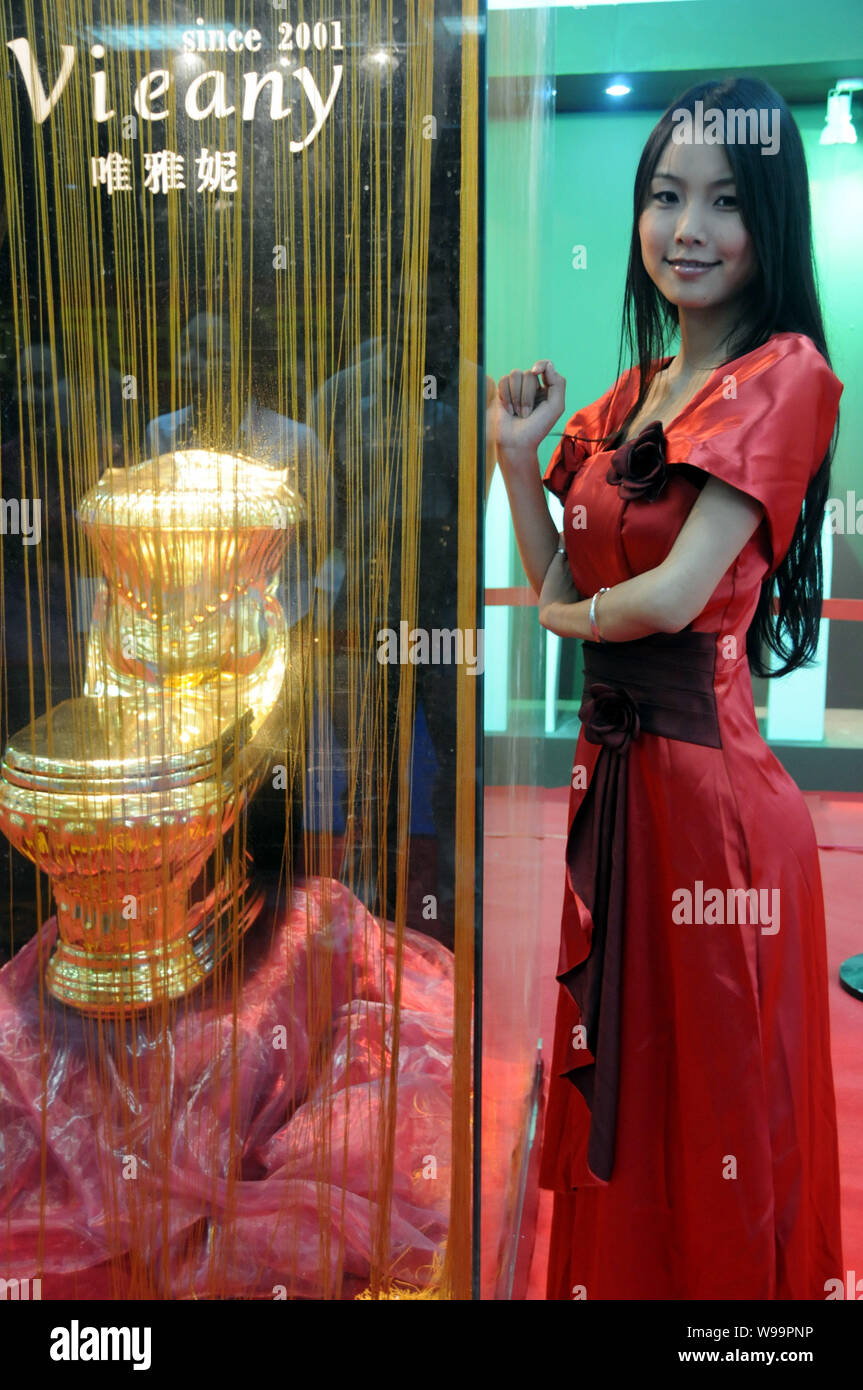 Un modello pone l'oro wc durante l'undicesimo mondiale Vertice igienica e Expo in Haikou, sud Chinas Hainan provincia, 22 novembre 2011. La Shiny s Foto Stock