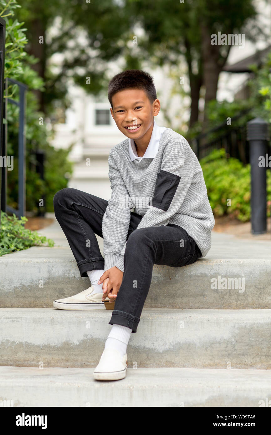 Ritratto di un giovane ragazzo asiatico sorridente fuori. Foto Stock
