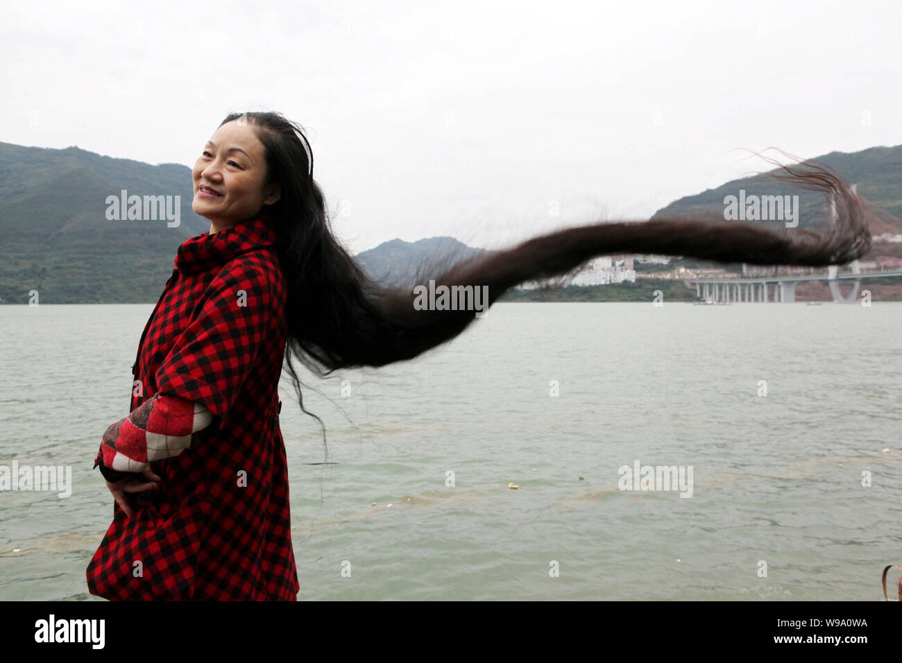 Migrante cinese Cheng Shiqun mostra i suoi capelli lunghi per contrassegnare il livello di acqua del fiume Yangtze raggiungendo i 174 metri in tre gole serbatoio a Yun Foto Stock