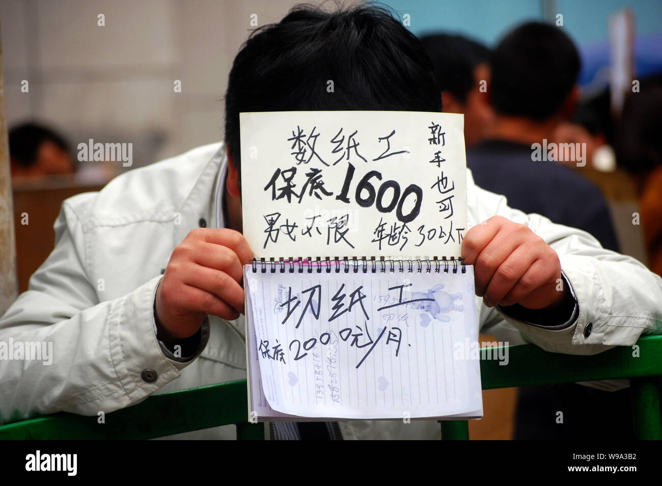 Una fabbrica cinese rappresentante mostra offerte di lavoro a un mercato del lavoro in Yiwu City East Chinas nella provincia di Zhejiang, 24 febbraio 2010. La penuria di manodopera Foto Stock