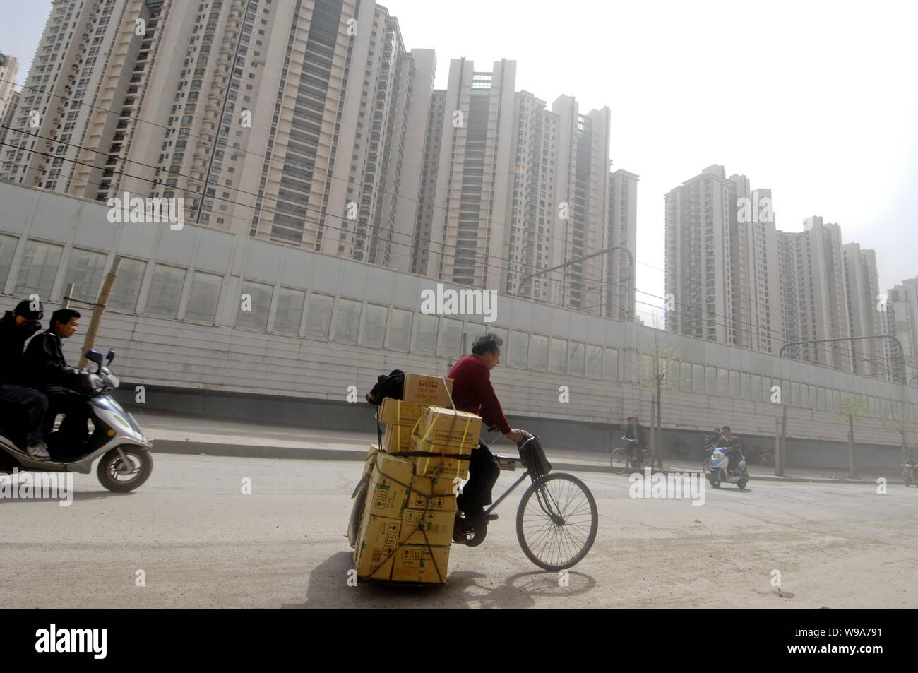 --FILE--ciclisti cinesi passano da un cluster di appartamento residenziale fabbricati in Cina a Shanghai, 27 aprile 2010. Nel tredicesimo mese consecutivo di ye Foto Stock