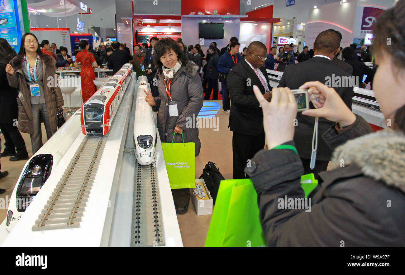 Una donna cinese pone con i modelli di CRH (Cina ferrovia ad alta velocità a) treni durante la moderna Ferrovia 2010 a Pechino, in Cina, 6 dicembre 2010. Foto Stock