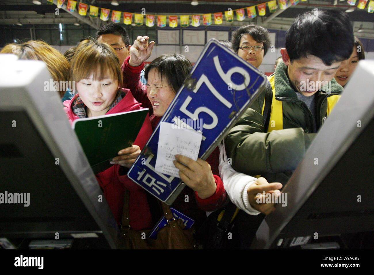 Auto cinesi i portatarga in coda fino a ottenere i numeri di coda per la registrazione del trasferimento della loro piastre a un veicolo di scambio nel mercato B Foto Stock