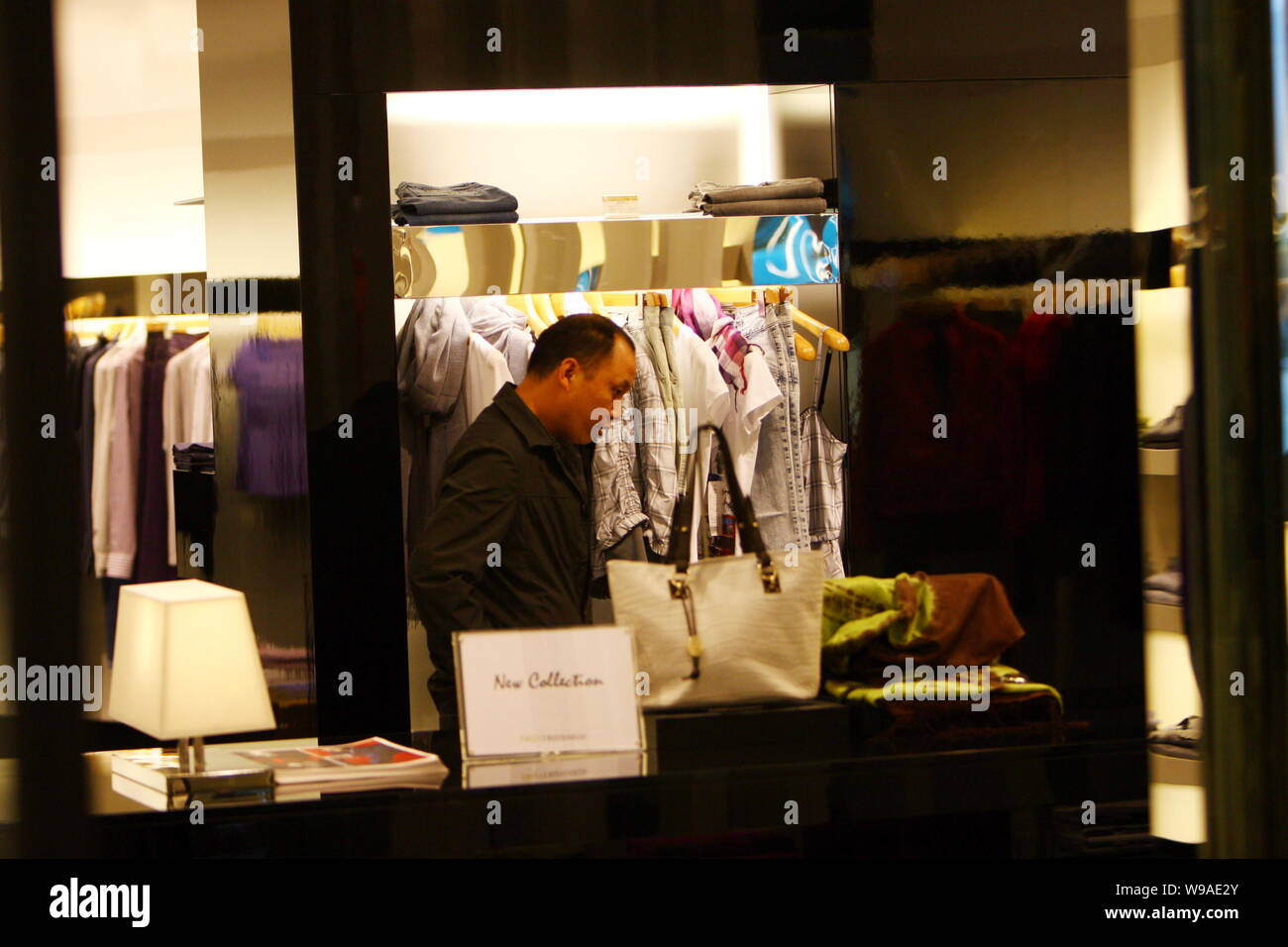 Un cliente è visto di shopping in una boutique Trussardi nella città di Ningbo, est Chinas nella provincia di Zhejiang, 15 marzo 2010. Vestiti importati da alcuni dei Foto Stock