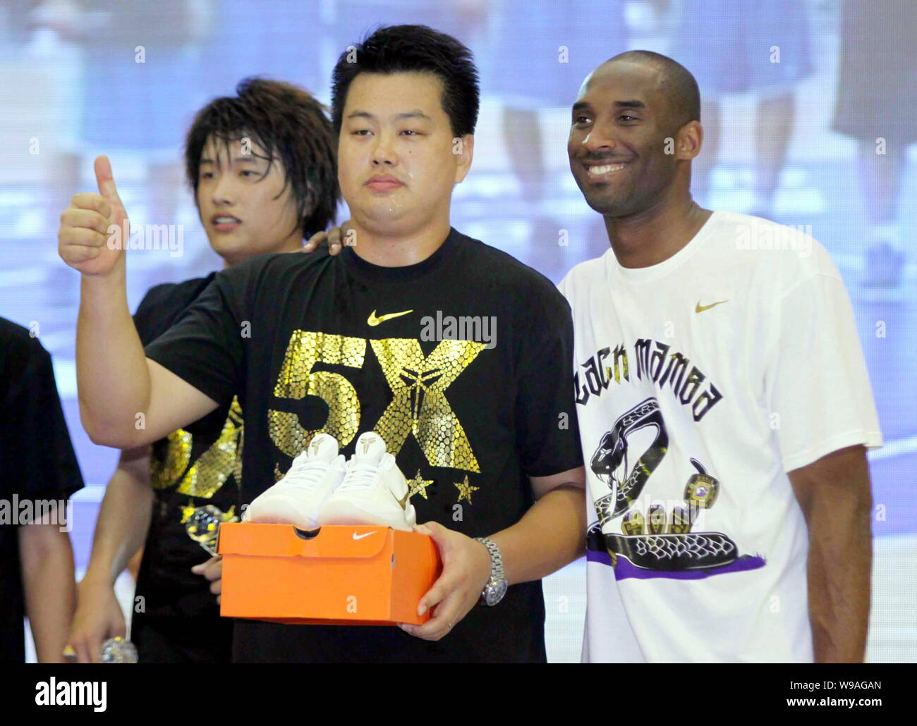 Giocatore di pallacanestro di NBA Kobe Bryant dei Los Angeles Lakers, a destra sorge accanto ad una ventola premiato con un paio di scarpe Nike in occasione di una riunione con il cinese f Foto Stock