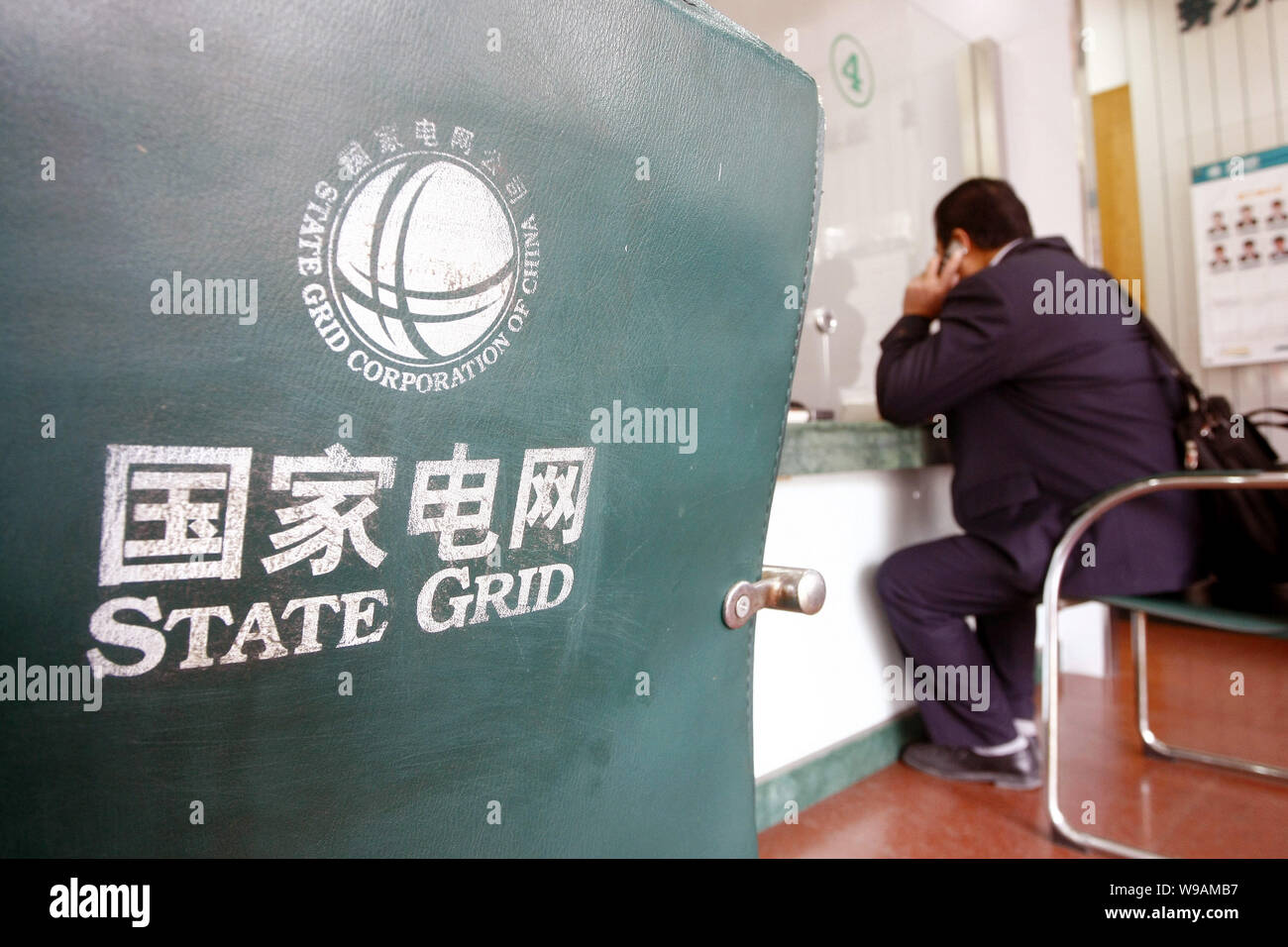 Un uomo cinese è visto presso una filiale della griglia di Stato in Cina a Shanghai, 22 dicembre 2010. I mondi consulente leader di marca e di valutazione marketin Foto Stock