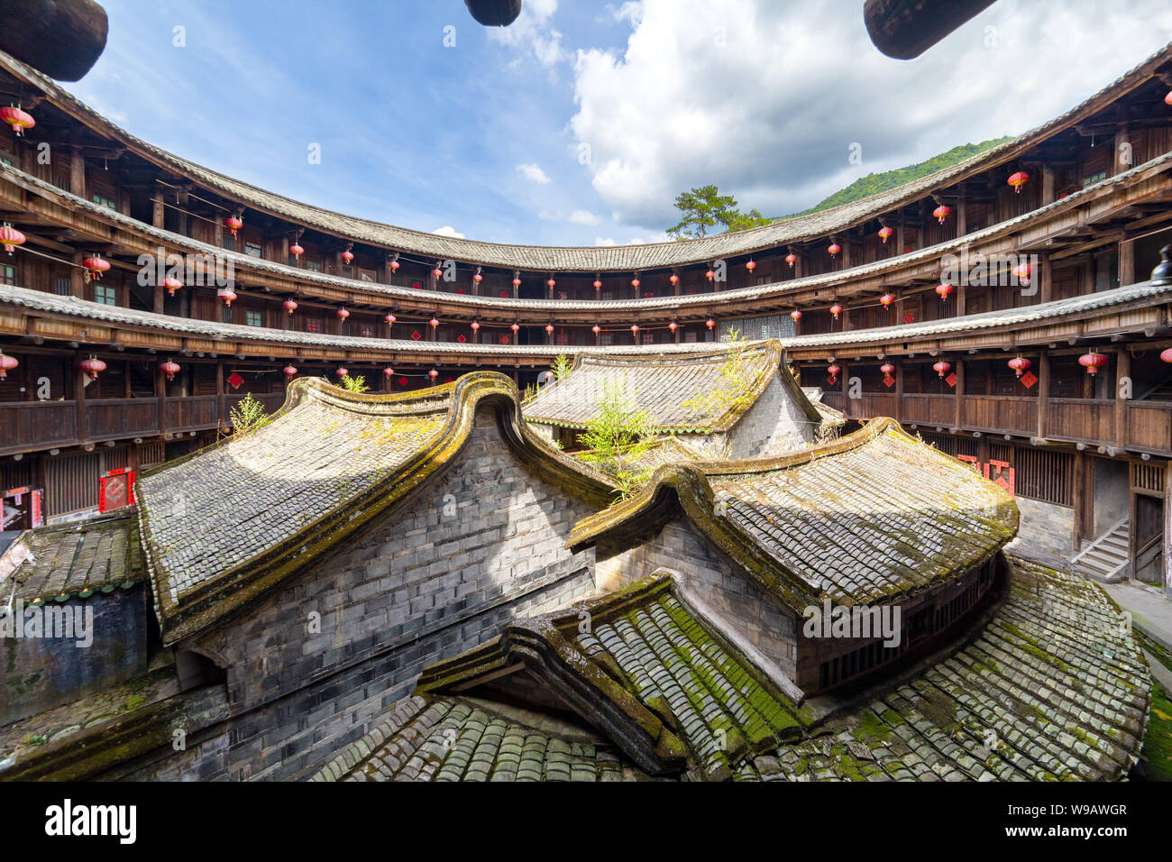 Il fujian tulou (hakka roundhouse). La carta rossa con parole cinesi sono baciata con lucky poesia Foto Stock