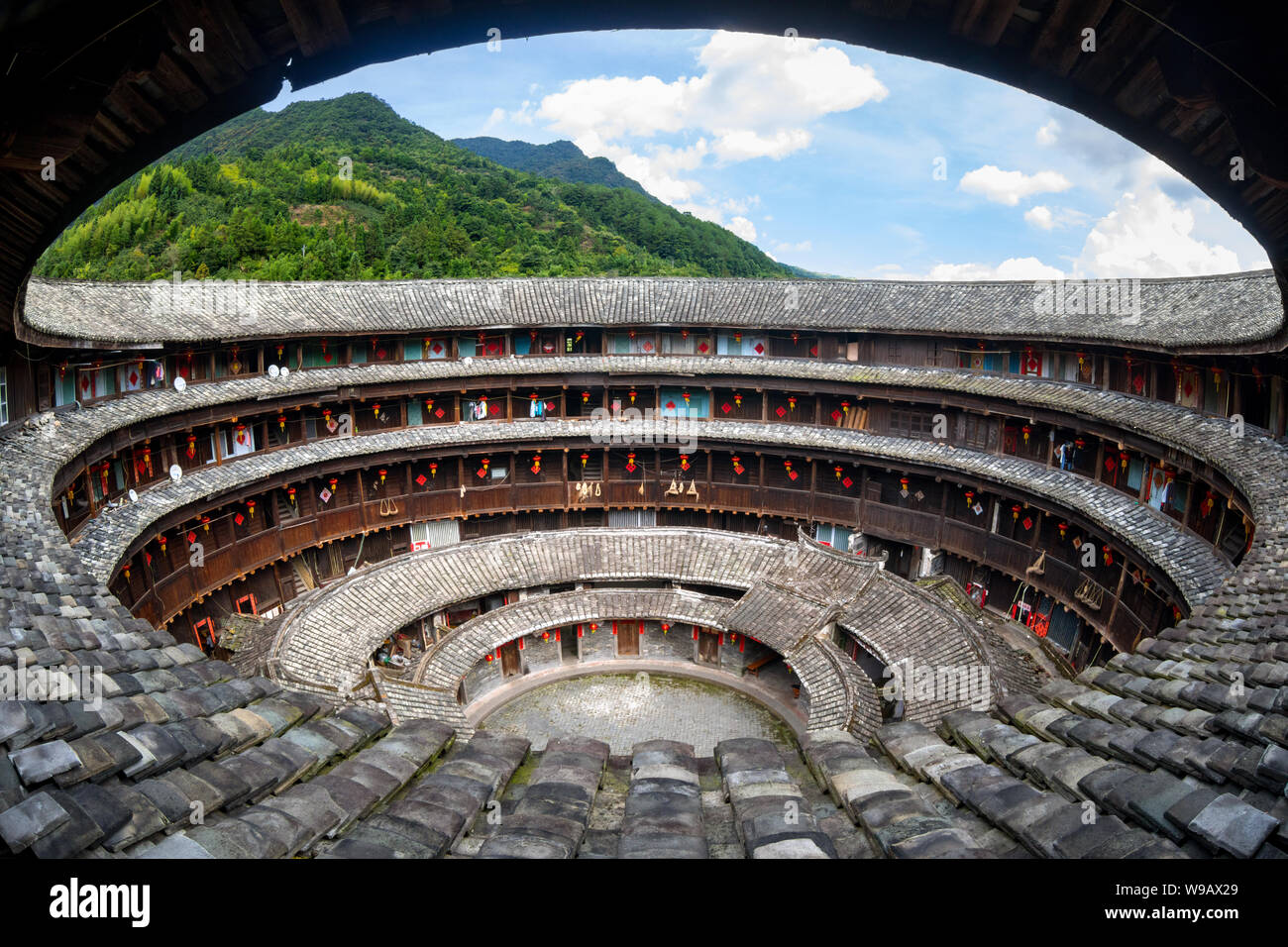 Il fujian tulou (hakka roundhouse). La carta rossa con parole cinesi sono baciata con lucky poesia Foto Stock