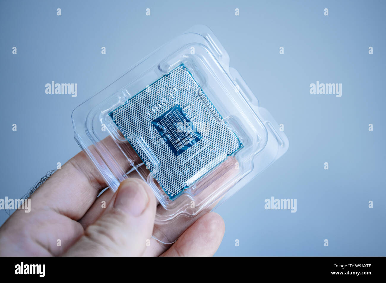 Parigi, Francia - 31 Maggio 2019: Close-up di ingegnere maschio mano azienda nuova professionale Intel Xeon E5-2687w v4 processore CPU in blister in plastica - isolare la tecnologia blu sullo sfondo Foto Stock