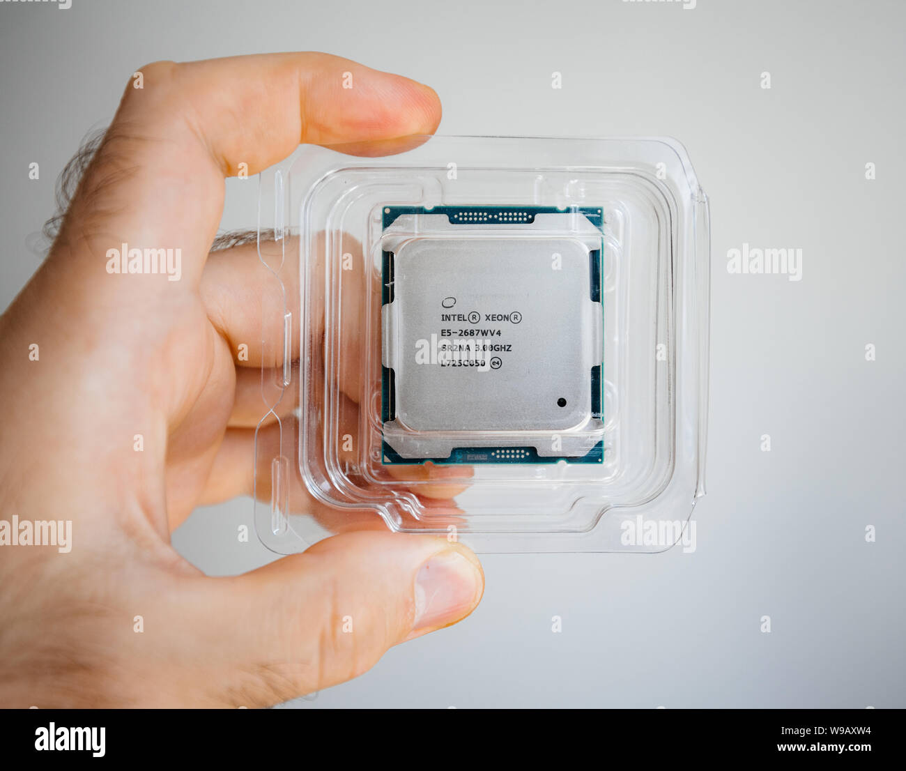 Parigi, Francia - 31 Maggio 2019: Close-up di ingegnere maschio dimostrando a mano nuovo professionale Intel Xeon E5-2687w v4 processore CPU in blister in plastica - isolato sullo sfondo della tecnologia Foto Stock