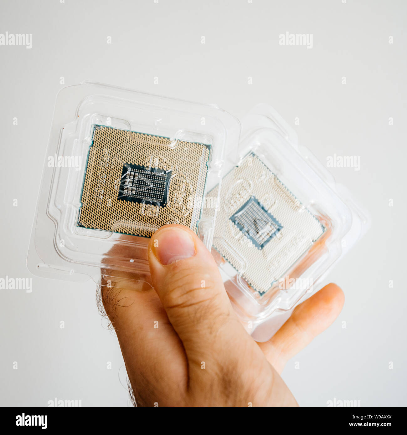 Parigi, Francia - 31 Maggio 2019: Close-up di ingegnere maschio mano che regge due nuovi professionale Intel Xeon E5-2687w v4 processore CPU in blister in plastica unboxing sfondo bianco Foto Stock