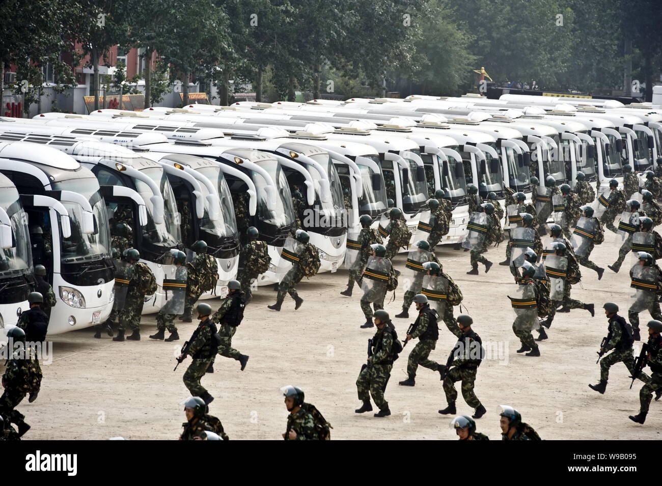 Cinese poliziotti paramilitari rush per gli autobus durante una distribuzione trapano a Pechino in Cina, 2 settembre 2010. La polizia di Pechino autorità detenevano 8 dr Foto Stock