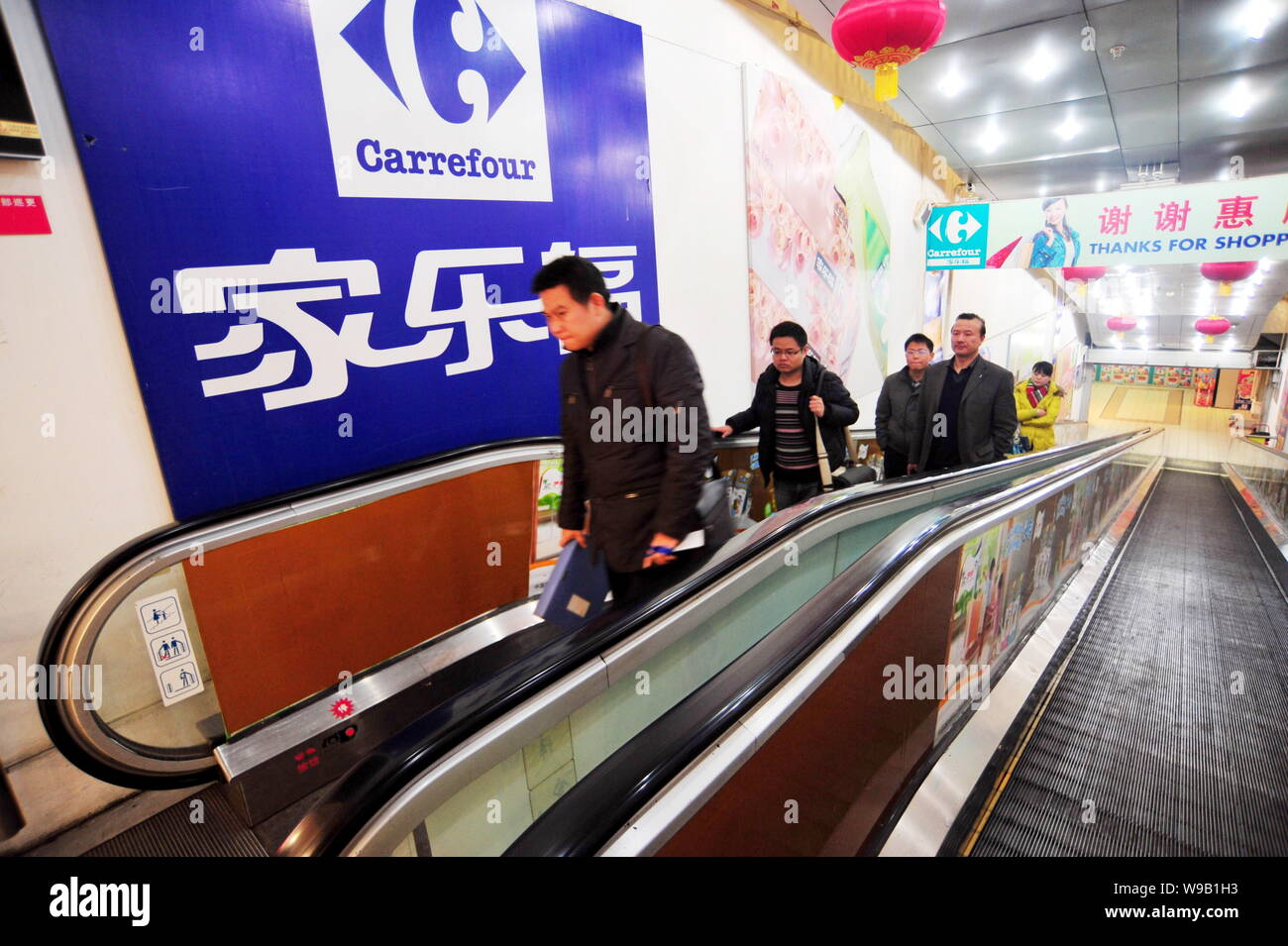 FILE -- Il popolo cinese prendere la scala mobile in un supermercato  Carrefour in Changsha city, porcellane centrale nella provincia del Hunan,  4 marzo 2010. Francese gi retail Foto stock - Alamy