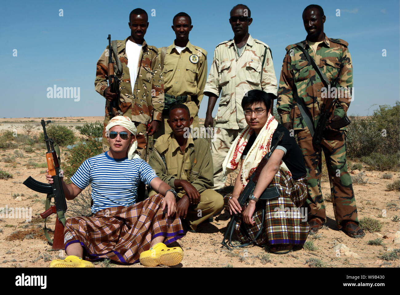 Reporters Zeng Yu, sinistra, e Zhang Yuan, destra, pongono con mercenari somali nel Puntland Membro, Somalia, 19 gennaio 2010. Due giovani cinesi journali Foto Stock