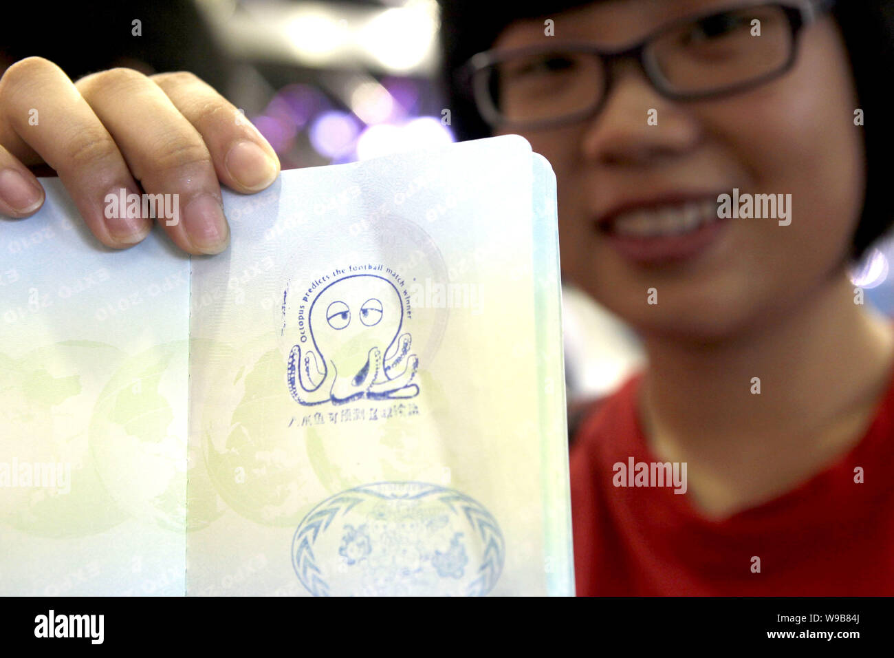 Una donna cinese mostra il passaporto Expo stampigliate con il polpo lucky guarnizione di tenuta a livello del DEVNET (lo sviluppo internazionale delle informazioni di associazione di rete) Foto Stock