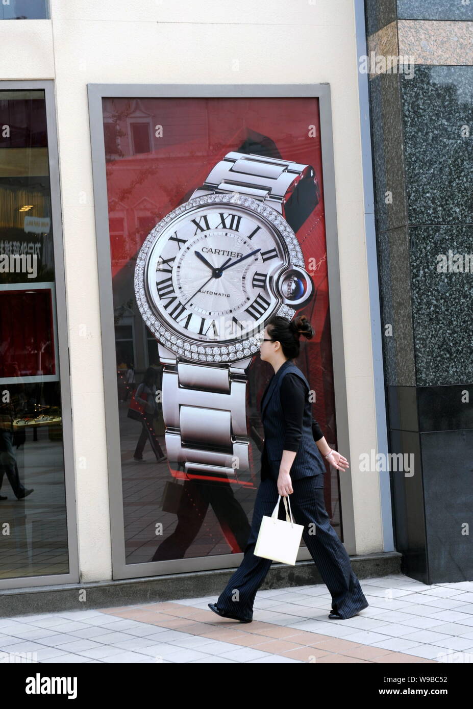 --FILE-- una donna cammina passato una boutique di Cartier a Pechino, in Cina, il 9 ottobre 2009. Giovani imprenditrici cinesi con un occhio per il lusso sono incrementato Foto Stock