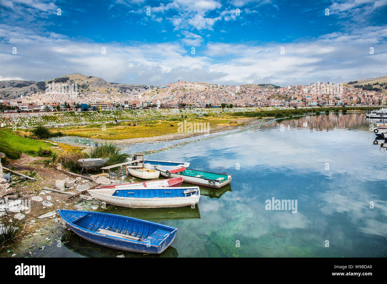 Barche e vista panoramica su Puno dal lago Titicaca, Perù Foto Stock