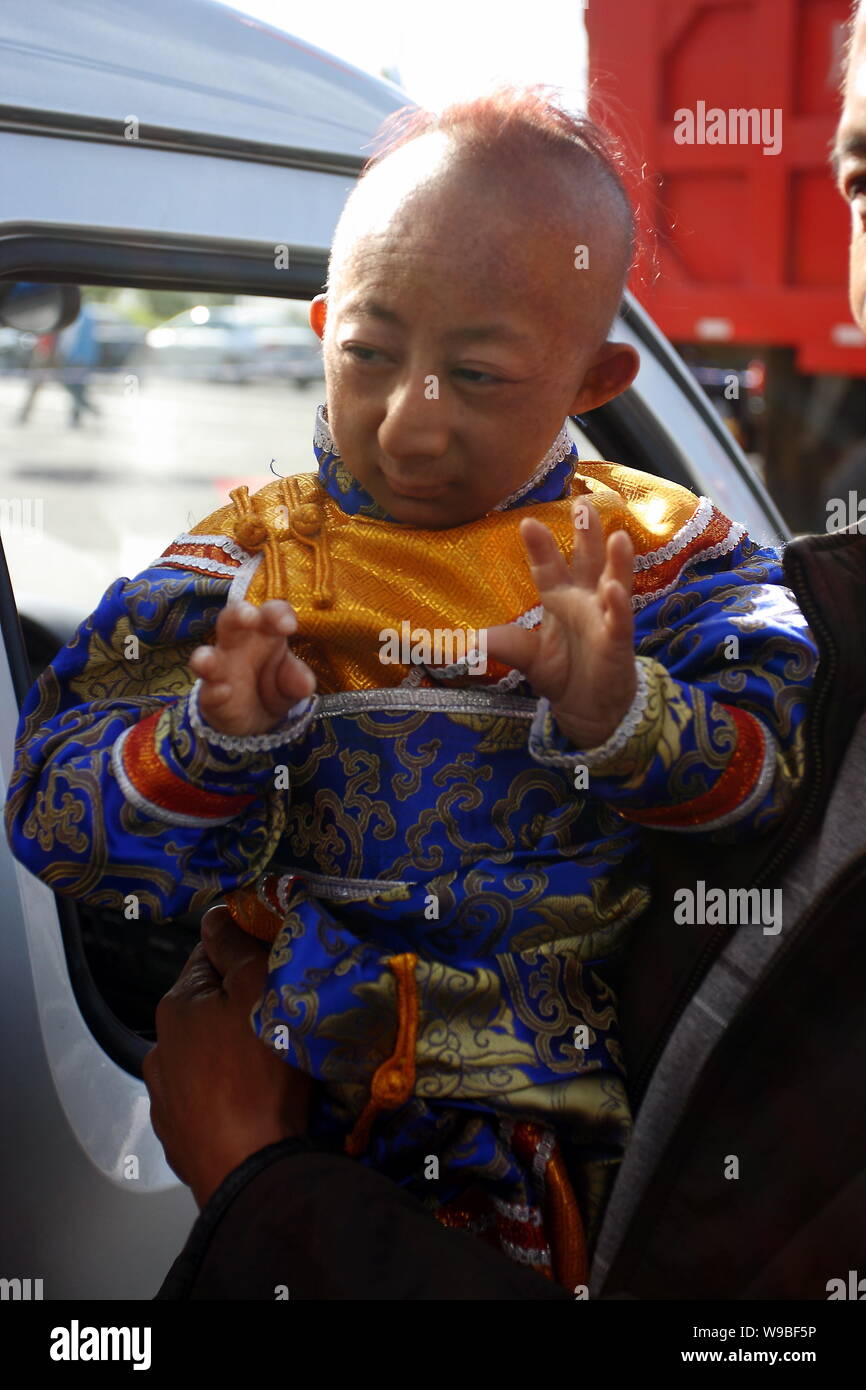 --FILE-- i mondi più breve uomo Egli Pingping è detenuto da un uomo nella città di Jilin, nordest Chinas provincia di Jilin, Agosto 29, 2009. I mondi più breve m Foto Stock