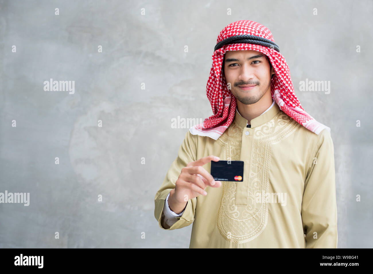 Bello e moderno uomo arabo mostra carta di credito Foto Stock