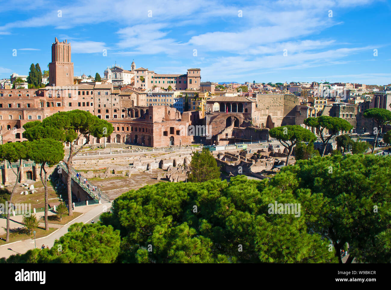 Rovine dei Mercati di Traiano, Foro Traiano e Casa dei Cavalieri di Rodi tra molte alte verdi alberi. Città vecchia di Roma, Italia. Soleggiata giornata autunnale. Shot Foto Stock