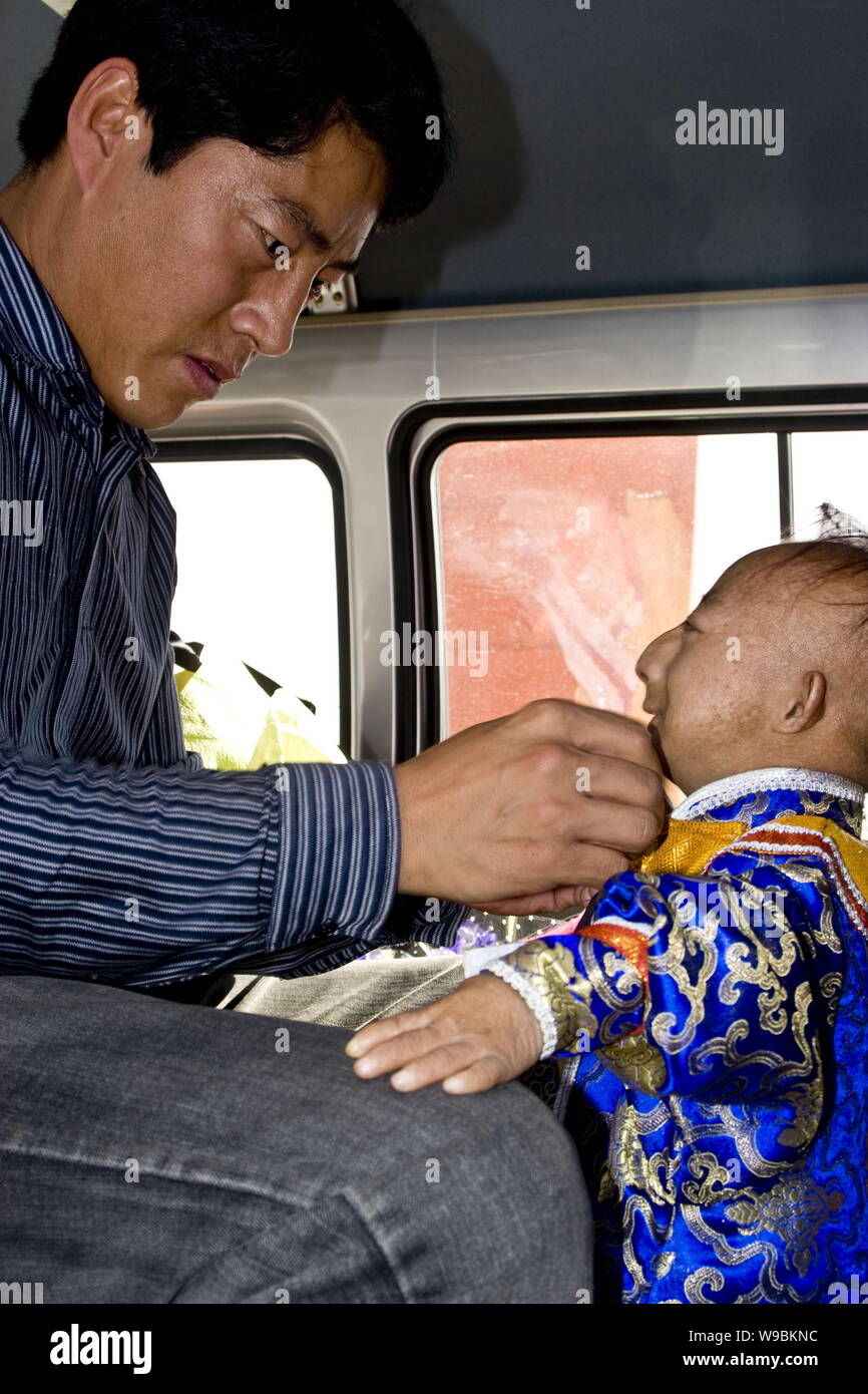 --FILE--i mondi più breve uomo Egli Pingping, destra, guarda al suo cognato facendogli indossare uniformi per una performance nella città di Jilin, nordest ch Foto Stock