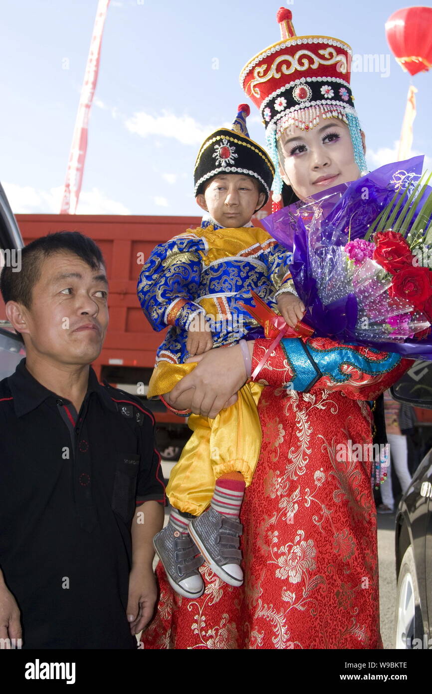 --FILE--i mondi più breve uomo Egli Pingping, centro è tenuto da un giocatore durante una performance nella città di Jilin, nordest Chinas provincia di Jilin, 29 Au Foto Stock