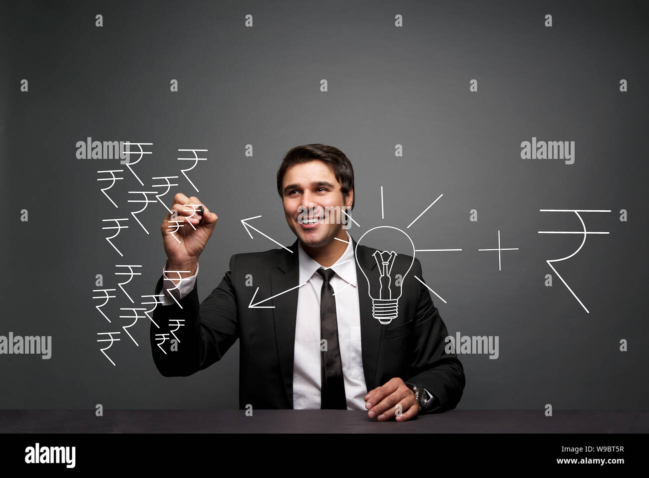 Uomo d'affari che fa i simboli della rupia Foto Stock