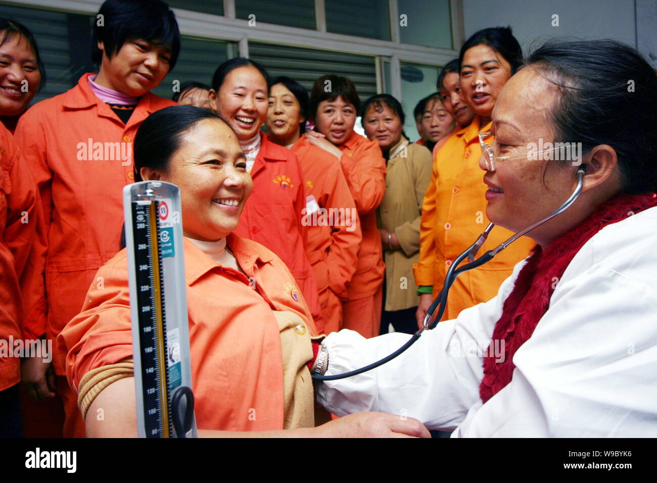 --FILE -- Un medico cinese esamina una femmina di lavoratore migrante in un ospedale di Chongqing Cina, 31 ottobre 2008. La Cina mira a rendere le cure sanitarie di base s Foto Stock