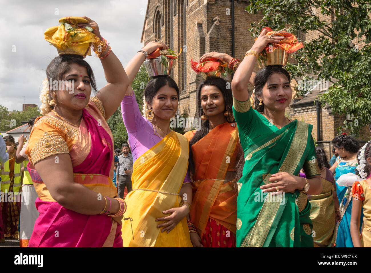 I devoti che porta bicchieri di latte, noto come"paal kudam, sulla loro testa durante il Tamil annuale Festival Chariot che passa chiesa di San Giovanni Evangelista, West Ealing Foto Stock