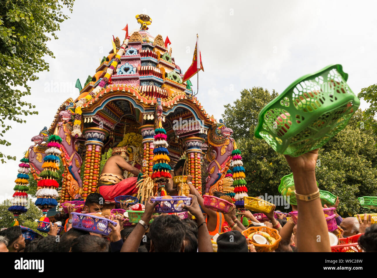I devoti che offrono ciotole di frutta per le divinità durante il carro Tamil Festival, un annuale pubblica indù processione in West Ealing, Londra Foto Stock