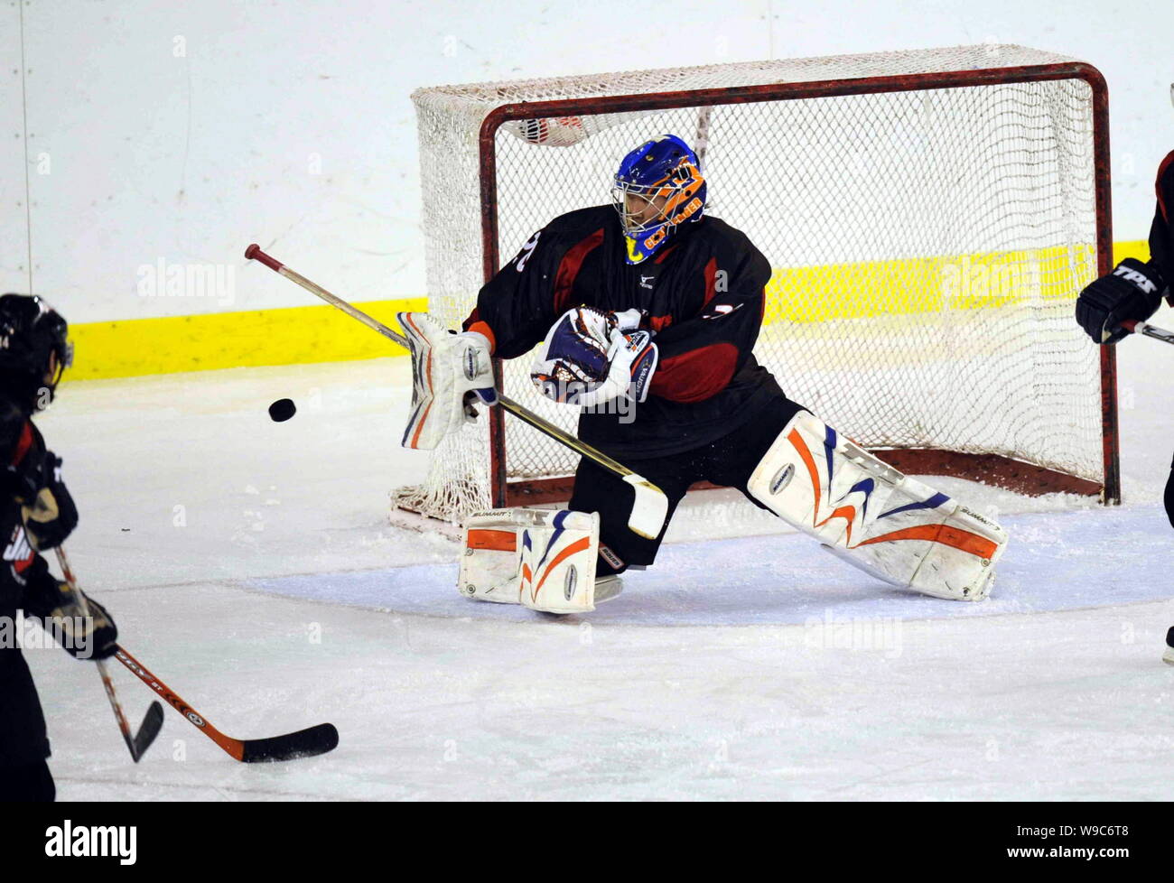 Portiere giapponese tenta di salvare un colpo da un giocatore ceco durante una mens hockey su ghiaccio corrispondono a Harbin xxiv Universiade Invernale nella città di Harbin, northe Foto Stock