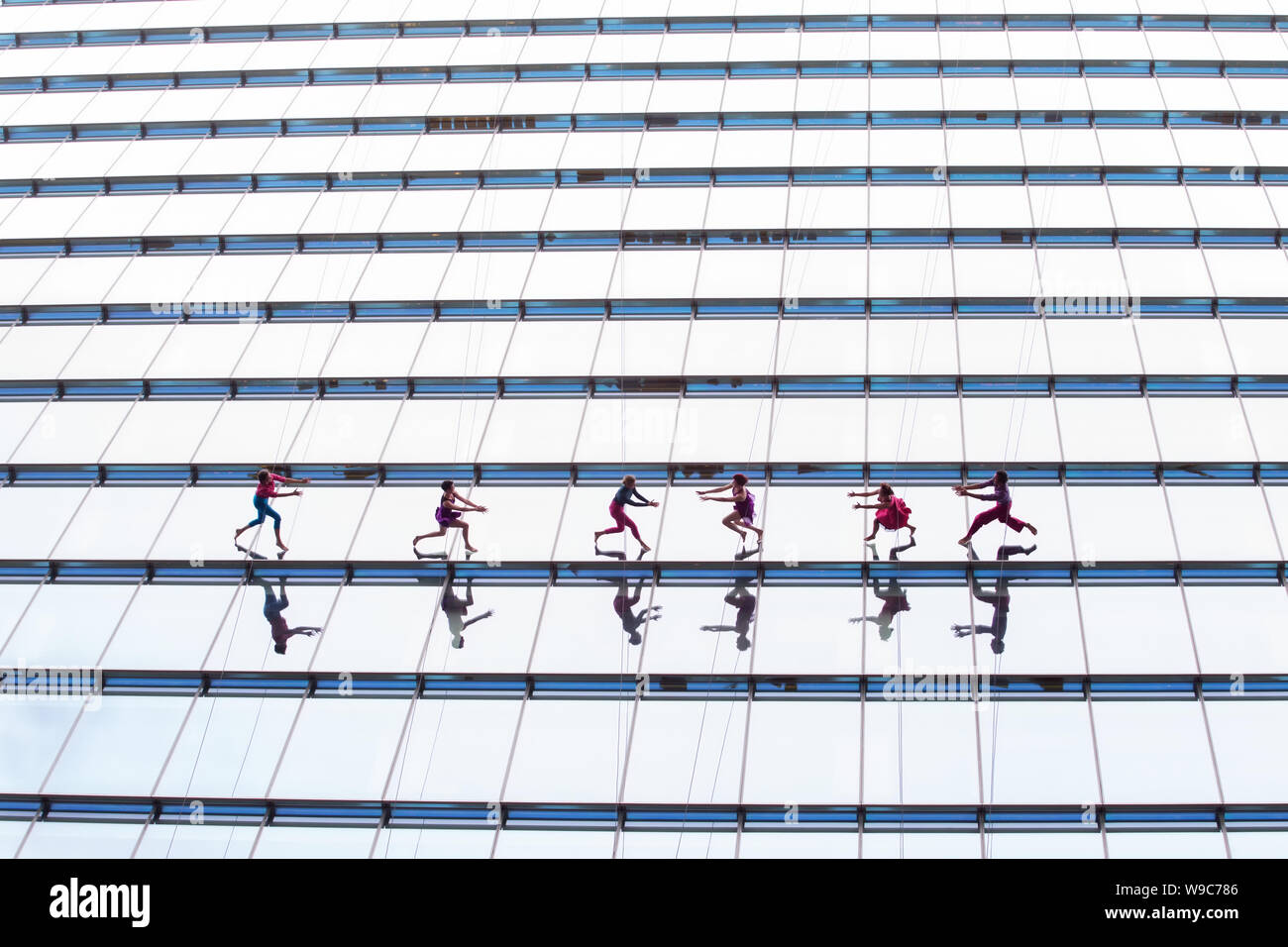 SYDNEY, Australia - agosto 20,2017: verticale dance company Bandaloop Ballando verso il basso dalla parte superiore di un 290ft alto grattacielo a Martin Place. Foto Stock