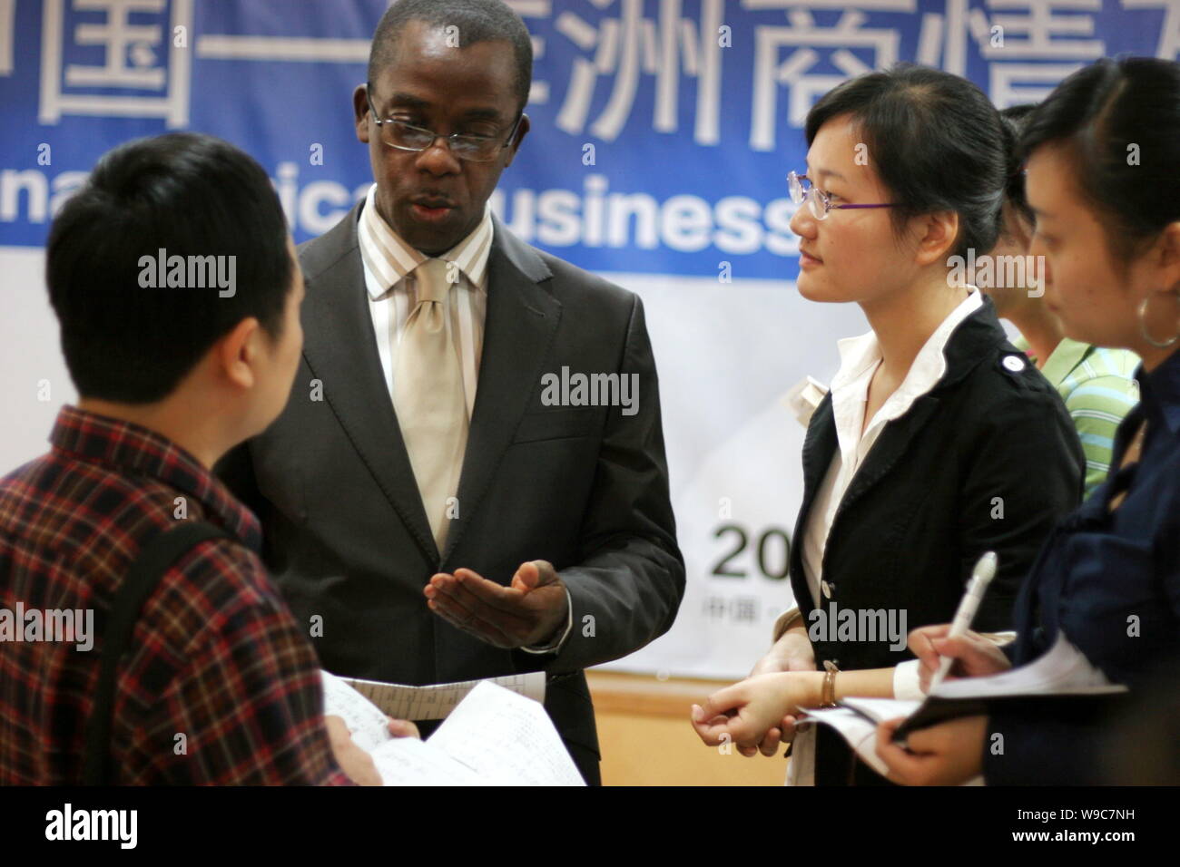 Visitatori cinesi parla con un africano di espositore alla China-Africa Business Information Exchange Fair a Wuhan City, porcellane centrale provincia di Hubei, W Foto Stock