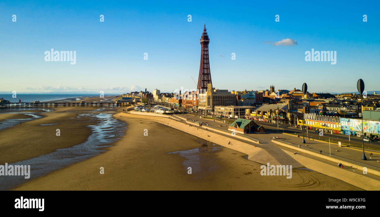 Vista aerea di una città costiera con una struttura torreggiante, spiaggia sabbiosa e cieli blu Foto Stock