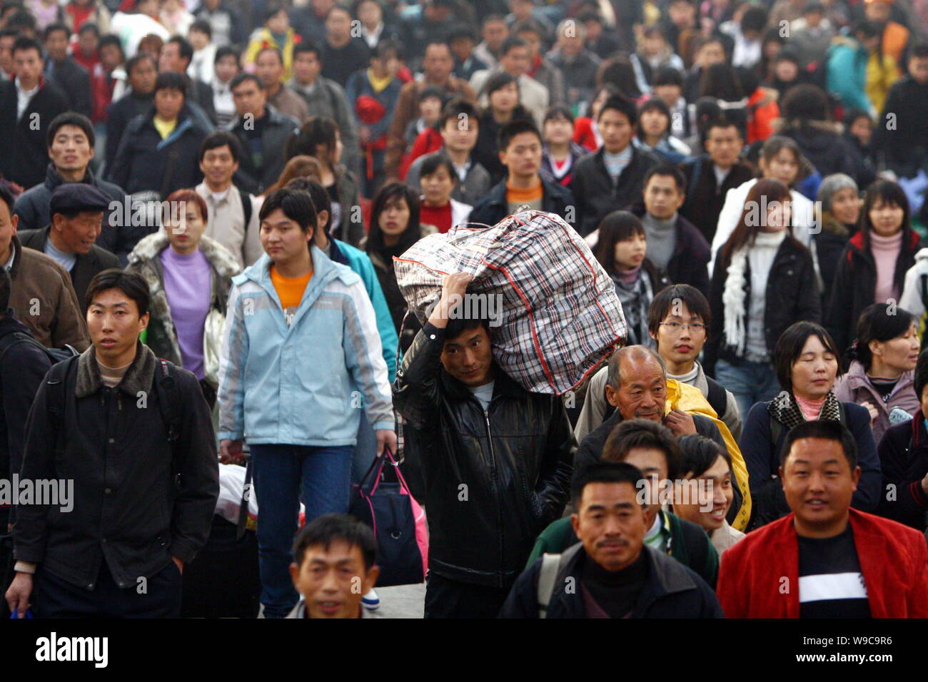 Una folla di passeggeri cinesi per la testa l'uscita a Fuyang stazione ferroviaria in città Fuyang, est Chinas provincia di Anhui, Domenica, 11 gennaio 2009. Semiscafi Foto Stock