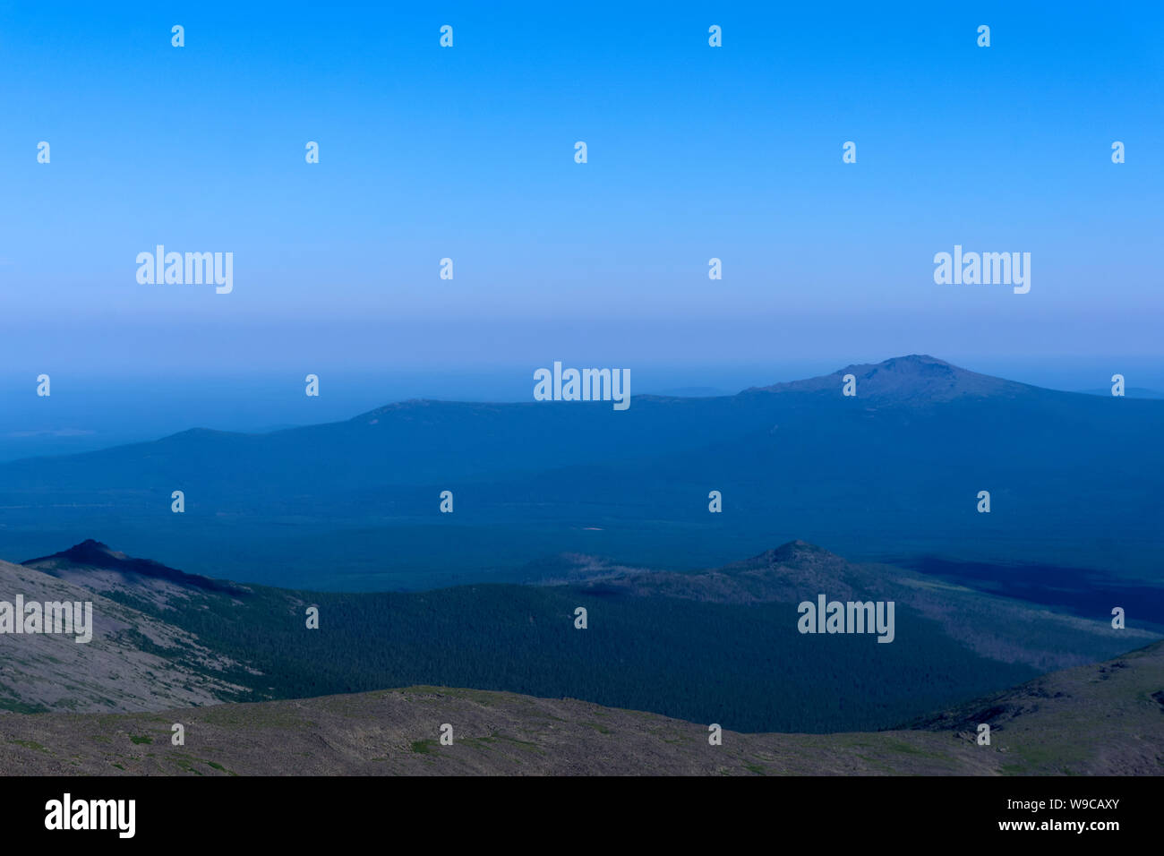 Dolcemente degradante delle montagne del nord degli Urali in un blu haze atmosferica Foto Stock