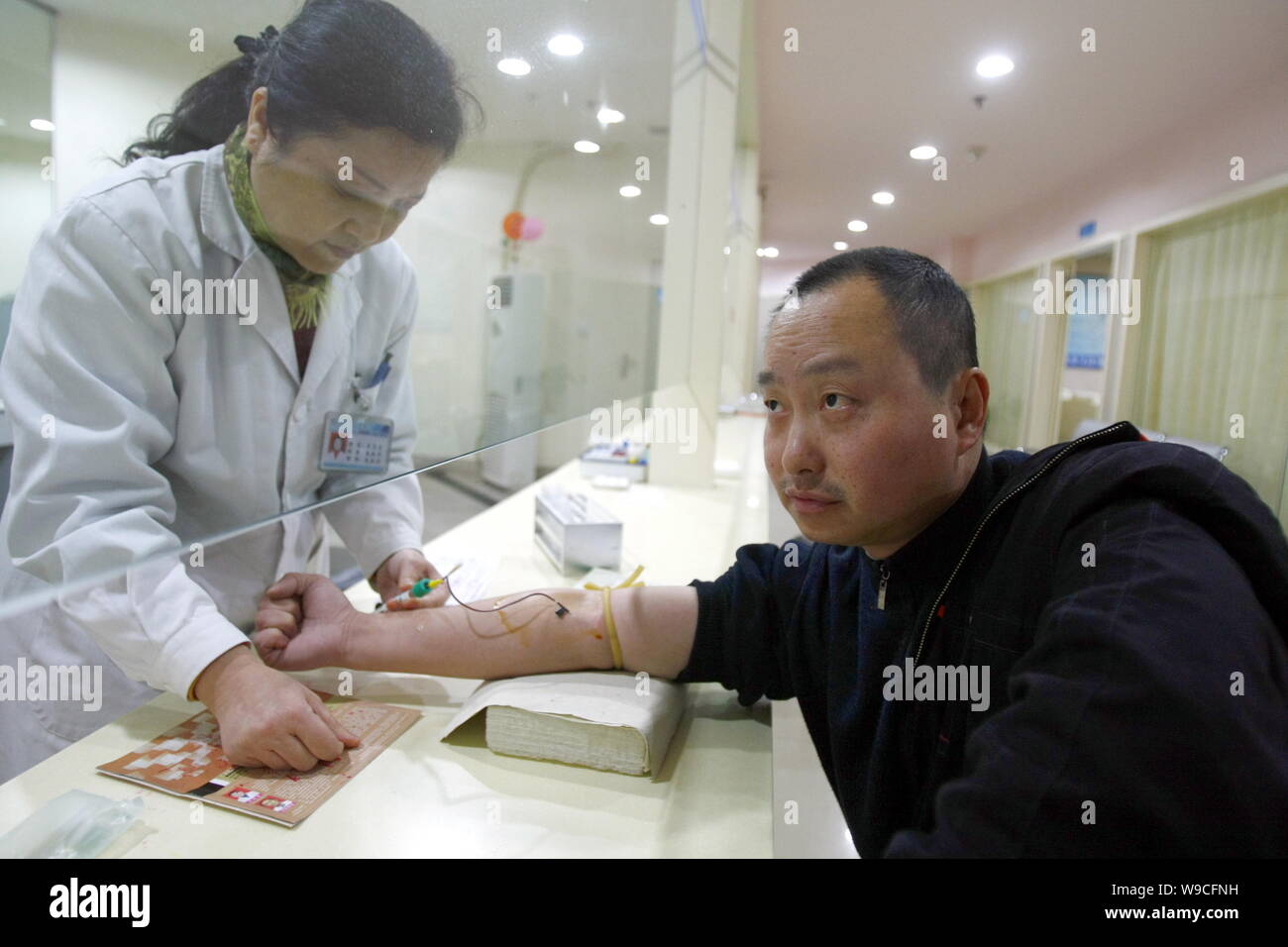 Un medico cinese diventa campione di sangue da un uomo in un ospedale di Chongqing Cina, 2 aprile 2009. La Cina mira a fare dei servizi sanitari di base dispon Foto Stock