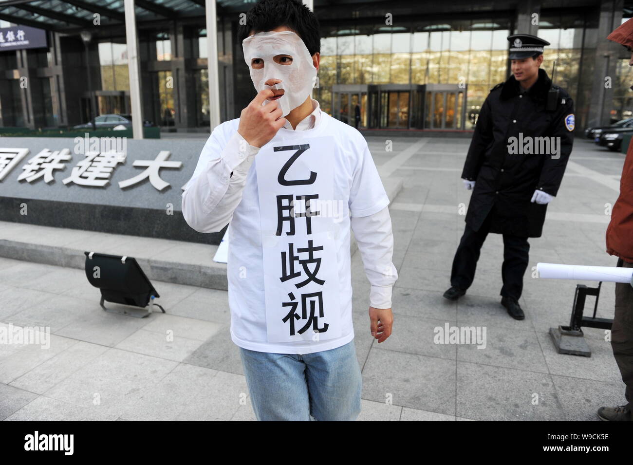 Un Cinese attivista per i diritti umani con segni dicendo la discriminazione contro il virus di epatite B vettori protestare di fronte alla sede centrale della Cina Ferrovia Foto Stock