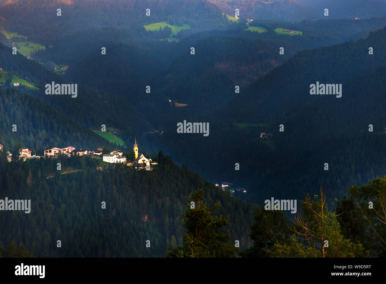 Una piccola cittadina al tramonto, sulle Dolomiti e le Alpi. Foto Stock