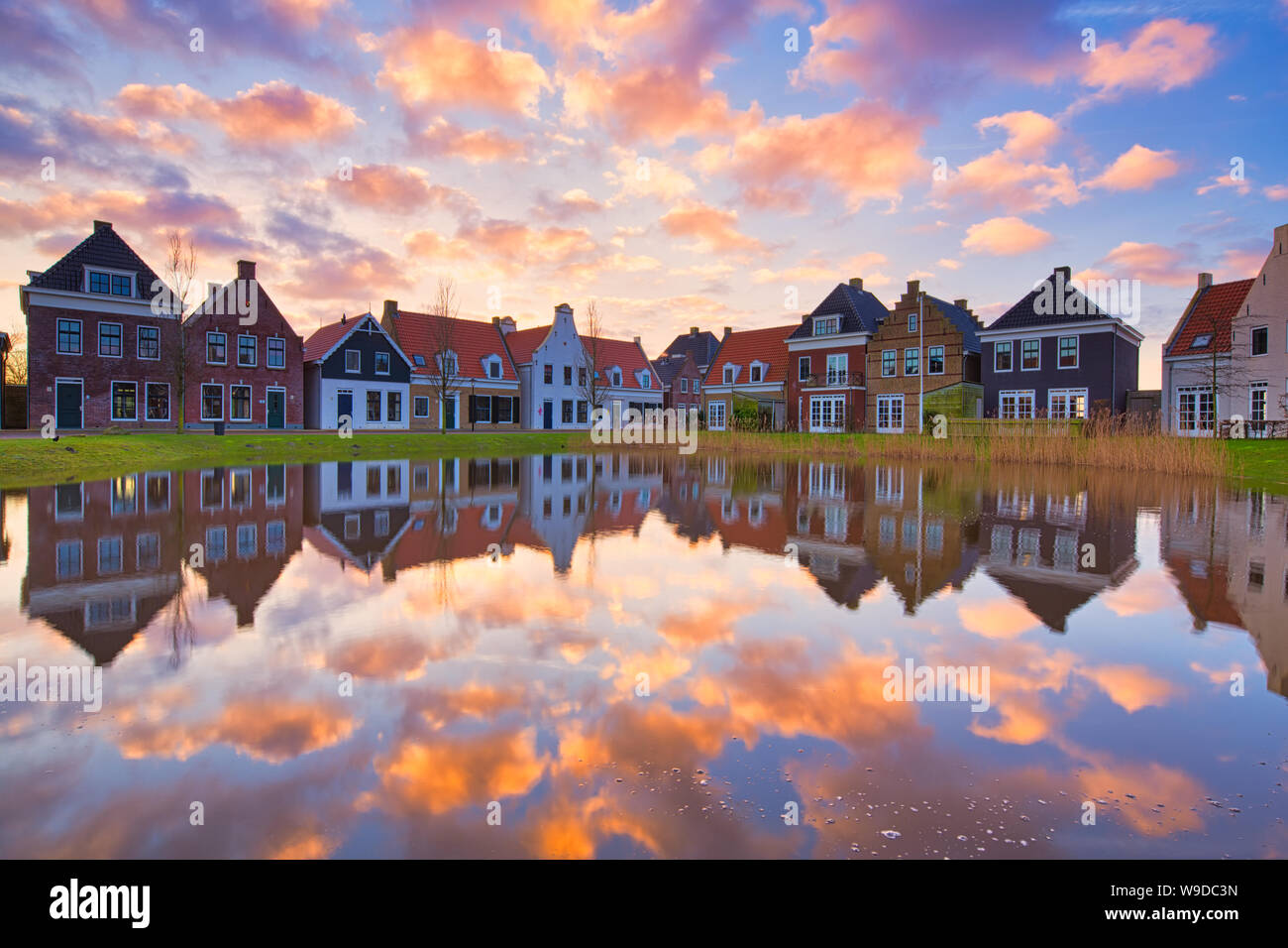 Case olandesi tradizionali con un canale e un bellissimo tramonto con riflessi nell'acqua - Travel immagine - Paesi Bassi - immagine di viaggio Foto Stock