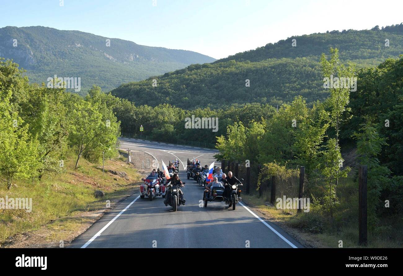 Il presidente russo Vladimir Putin, destra, cavalca un motociclo a fianco della notte lupi biker gang leader Alexander 'il chirurgo' Zaldastanov, sinistra, sul loro modo di Babylon di ombra bike show e camp Agosto 10, 2019 vicino a Sevastopol, Crimea, Russia. In sella alle spalle di Putin in pillion sul motociclo è agire governatore di Sevastopol Mikhail Razvozhayev e capo della Repubblica di Crimea Sergei Aksyonov è il sidecar. Foto Stock