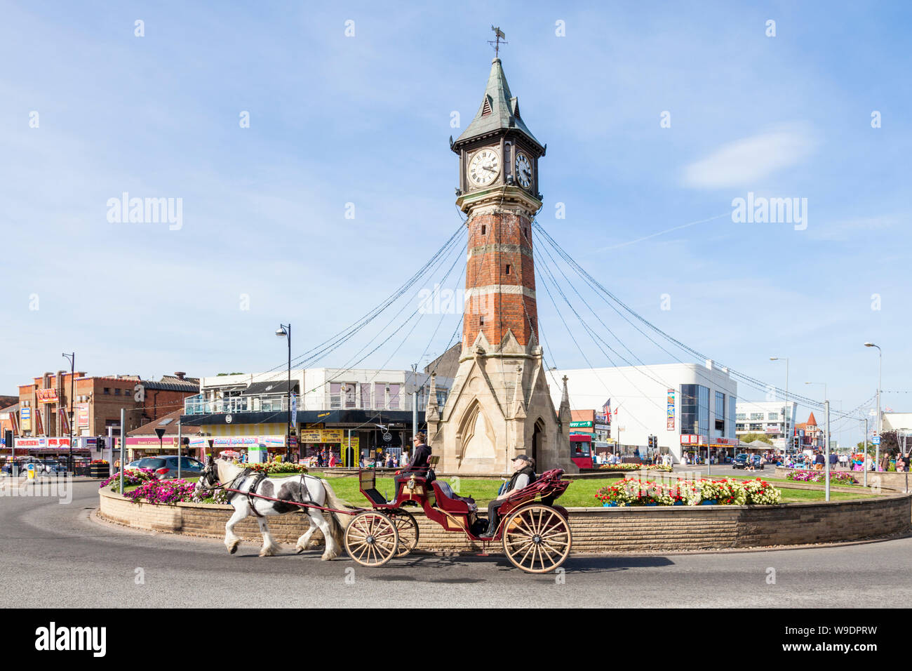 Cavallo e Carrozza passando dalla torre dell'Orologio, Skegness Town Center, Lincolnshire, England, Regno Unito Foto Stock