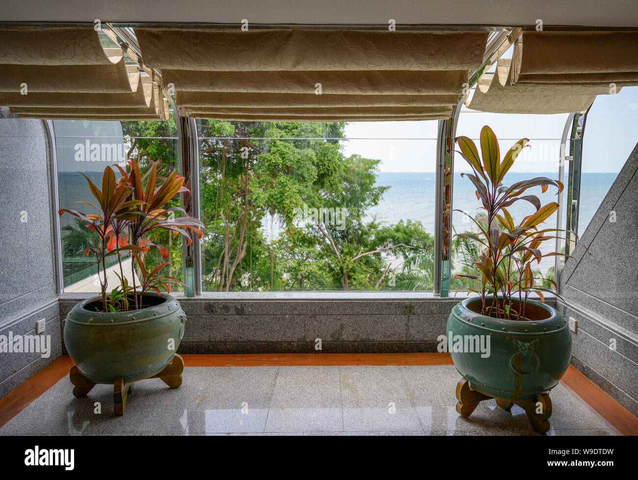 Struttura interna in vasi di argilla con tende dorate tropicale con vista sul mare Foto Stock